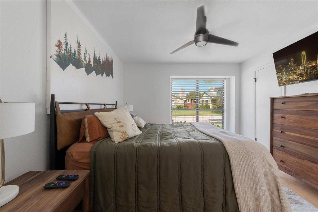 1805 W Spring Creek Parkway, #MM2, Plano, TX 75023 Bright bedroom featuring a large window with horizontal blinds, a ceiling fan, and wood-finish flooring