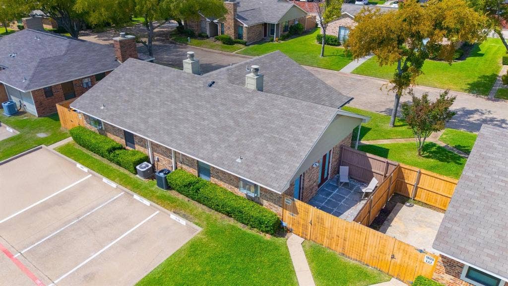 1805 W Spring Creek Parkway, #MM2, Plano, TX 75023 Brick exterior with a gray shingled roof, featuring a fenced private patio with paving stones