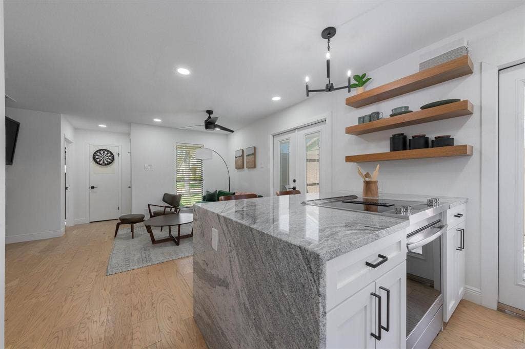 1805 W Spring Creek Parkway, #MM2, Plano, TX 75023 Kitchen island with a waterfall countertop, built-in cooktop, and integrated oven