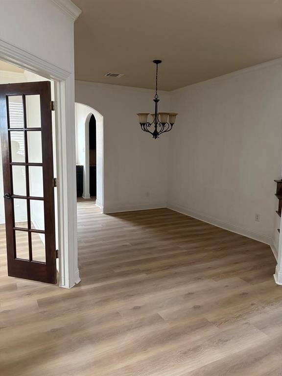 Wood-finish flooring throughout, with crown molding and a dark-finish chandelier