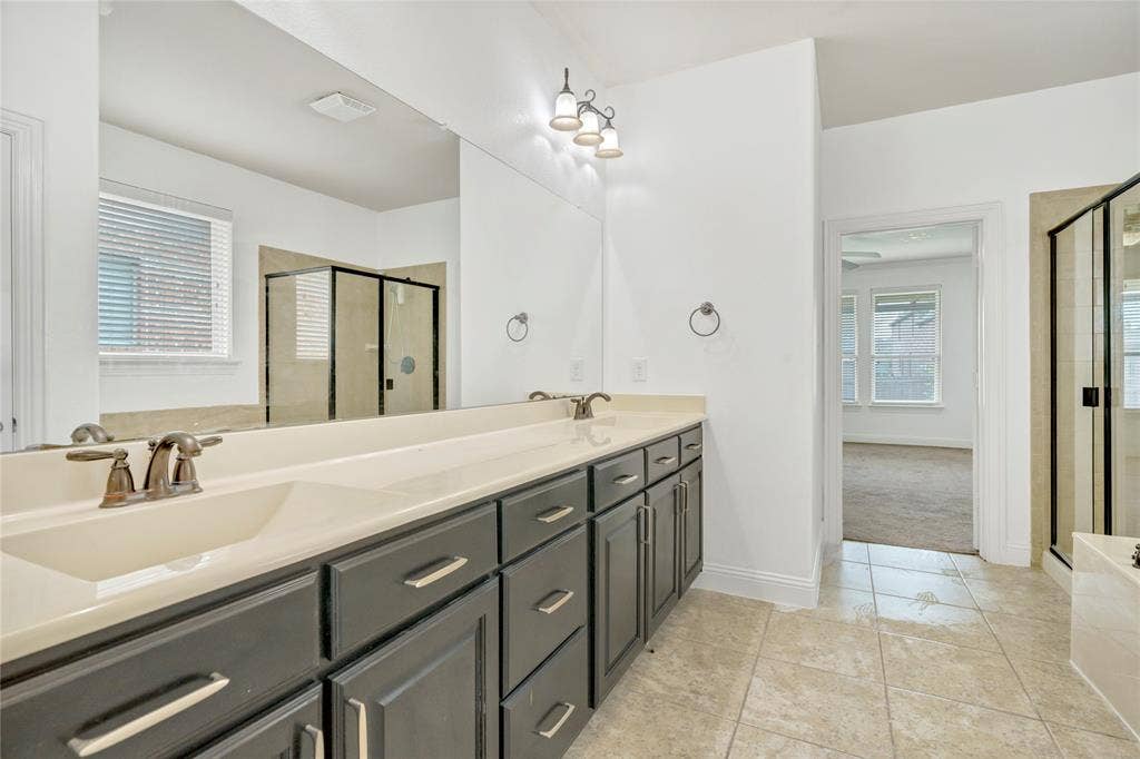 Dual vanity with integrated sinks, dark wood-finish cabinetry, and brushed nickel fixtures