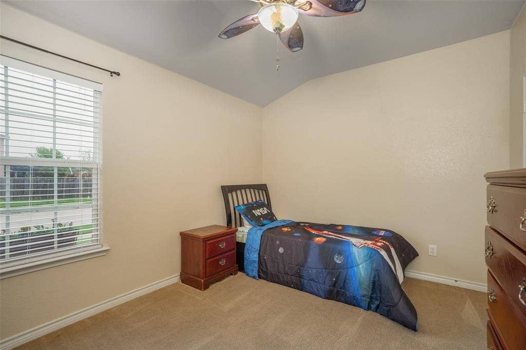 2035 Matagorda Lane, Grand Prairie, TX 75052 Carpeted room featuring a window with blinds, a ceiling fan, and sloped ceiling