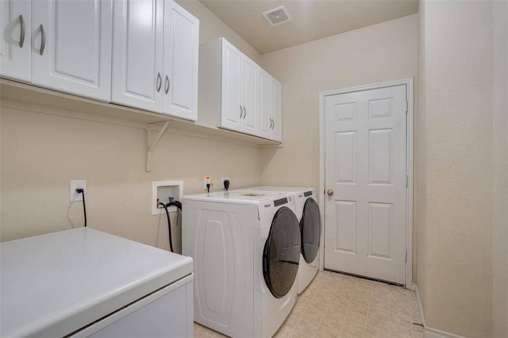 2035 Matagorda Lane, Grand Prairie, TX 75052 White upper cabinetry with brushed nickel hardware, light neutral wall paint, and tiled flooring