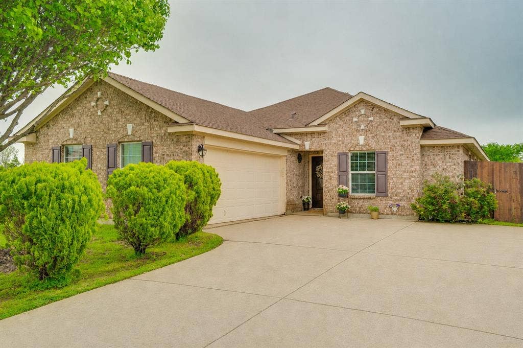 2035 Matagorda Lane, Grand Prairie, TX 75052 Brick exterior with a gabled roofline and a two-car garage