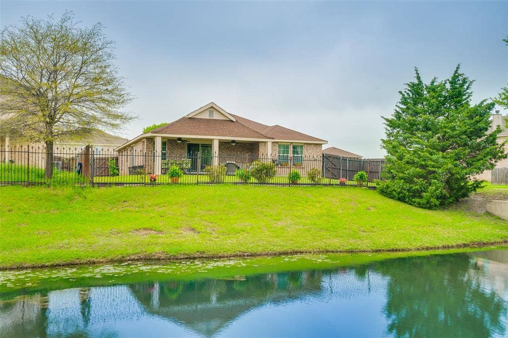 2035 Matagorda Lane, Grand Prairie, TX 75052 Brick exterior with a covered patio, gabled roofline, and established landscaping
