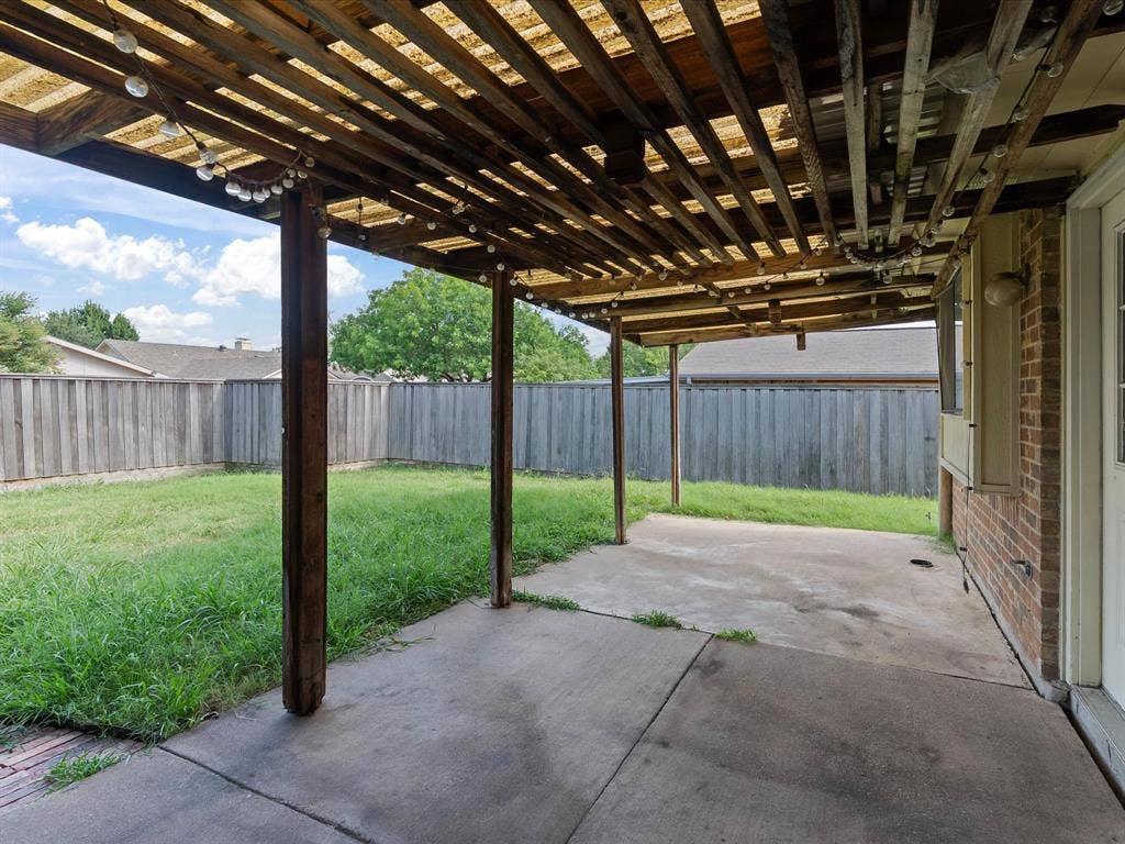 7612 Jerome Drive, Plano, TX 75025 Covered concrete patio with wooden slat pergola and brick exterior