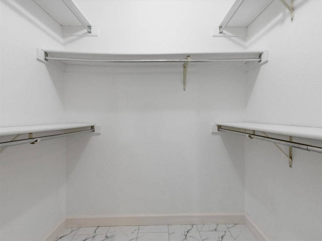 7612 Jerome Drive, Plano, TX 75025 White shelving system with hanging rods, tile flooring, and white walls