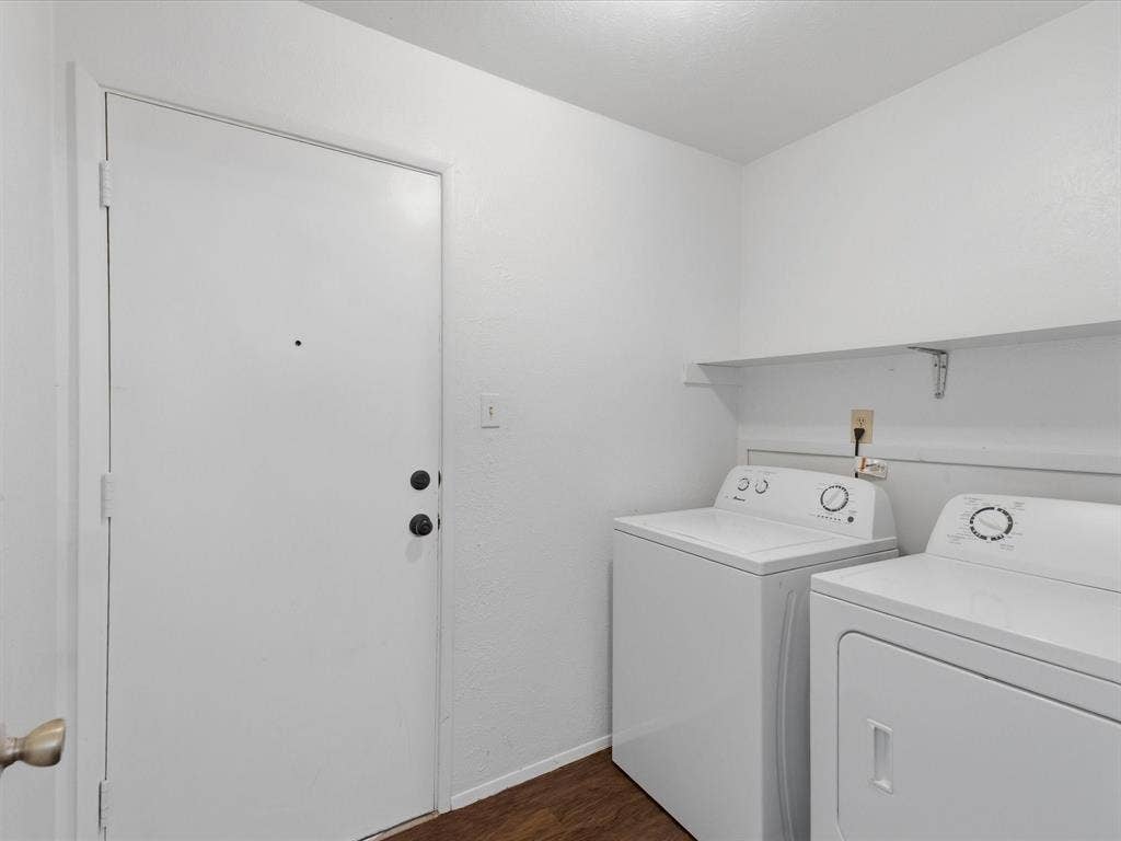 7612 Jerome Drive, Plano, TX 75025 Laundry area with wood-finish flooring, a white shelving unit, and a white entry door with matte black hardware