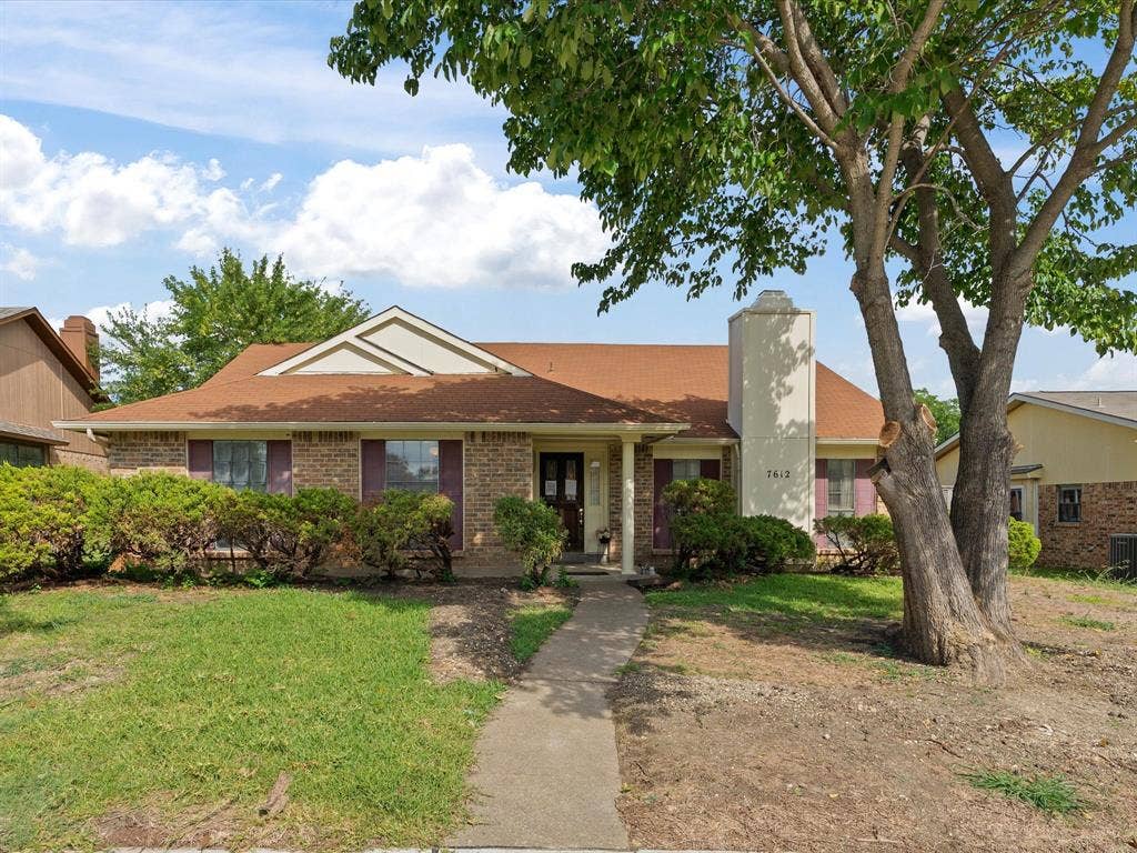 7612 Jerome Drive, Plano, TX 75025 Brick exterior with a shingled roof, prominent chimney, and mature front yard tree
