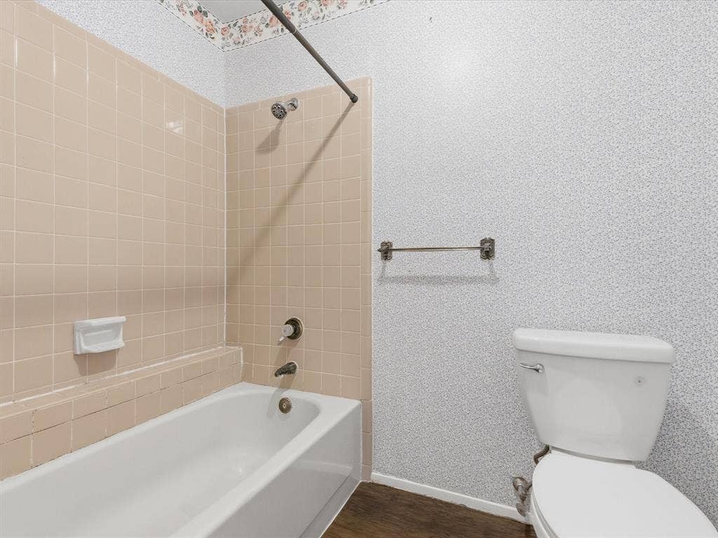 7612 Jerome Drive, Plano, TX 75025 Bathtub with a shower fixture, wall-mounted soap dish, and a white toilet