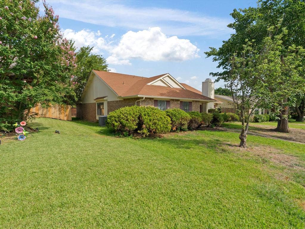7612 Jerome Drive, Plano, TX 75025 Brick exterior with a brown shingle roof and a prominent chimney structure
