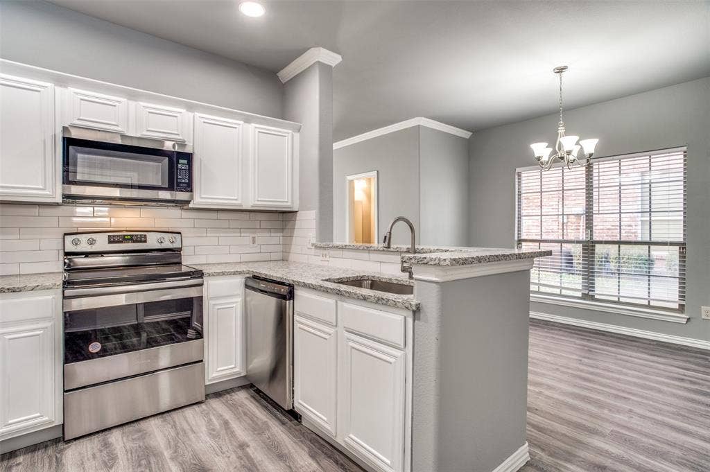 2364 Calendar Court, Grand Prairie, TX 75050 Kitchen featuring white cabinetry, stainless steel appliances, granite countertops, and a subway tile backsplash