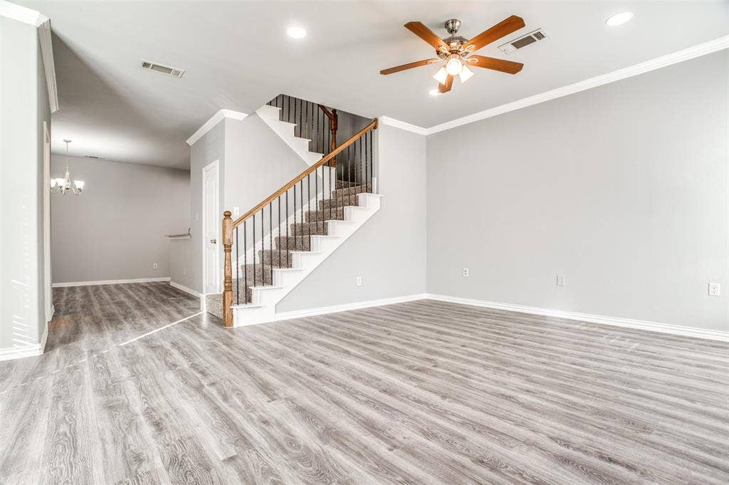2364 Calendar Court, Grand Prairie, TX 75050 Wood-finish flooring, staircase with carpeted treads, wrought iron balusters, wood handrail, and recessed lighting