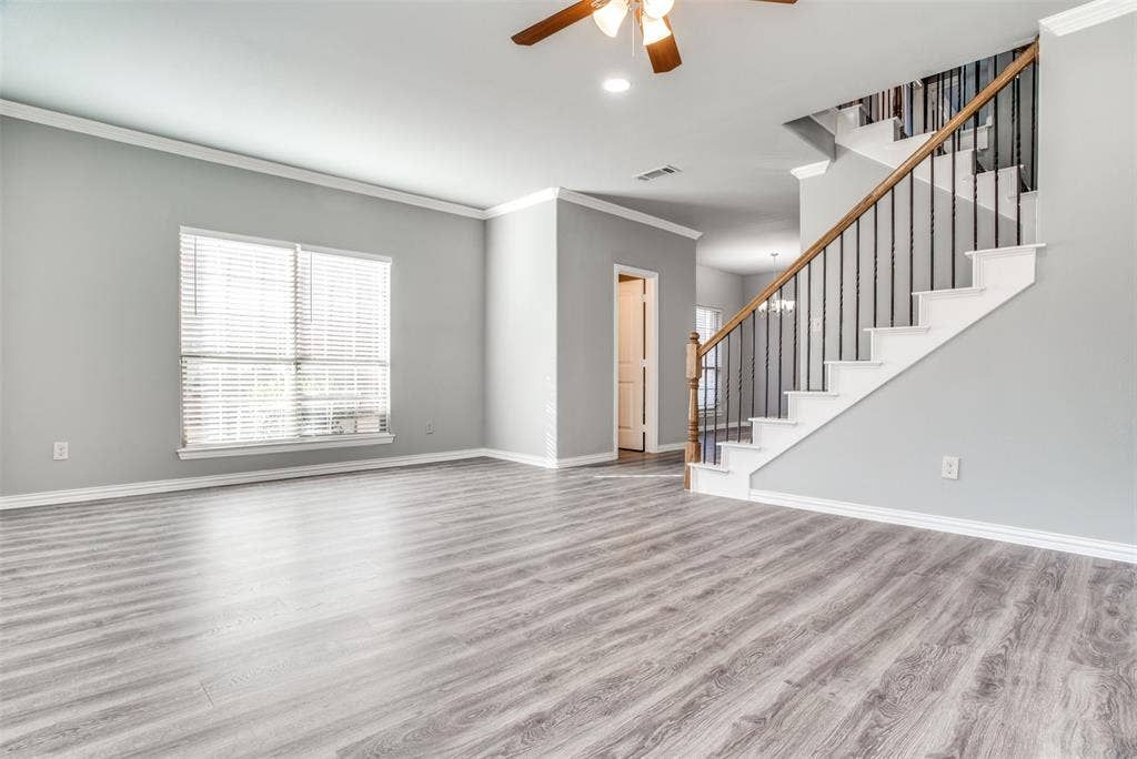 2364 Calendar Court, Grand Prairie, TX 75050 Wood-finish flooring, staircase with wrought iron balusters and wood handrail, crown molding, ceiling fan with light fixture, and window with blinds