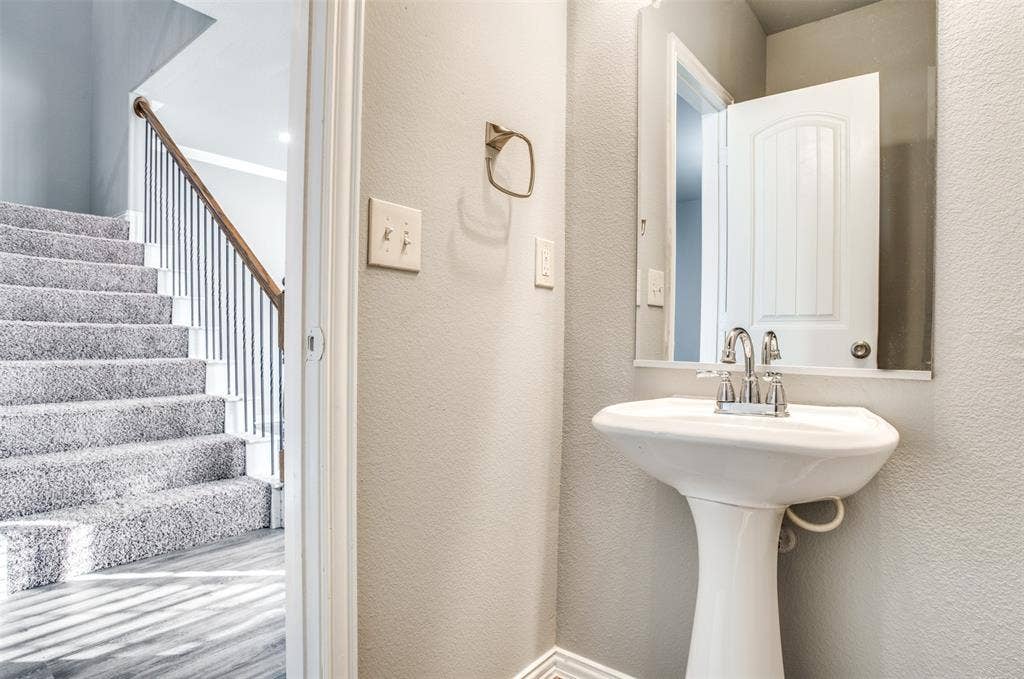 2364 Calendar Court, Grand Prairie, TX 75050 Pedestal sink with chrome faucet, wall-mounted mirror, and neutral wall tones