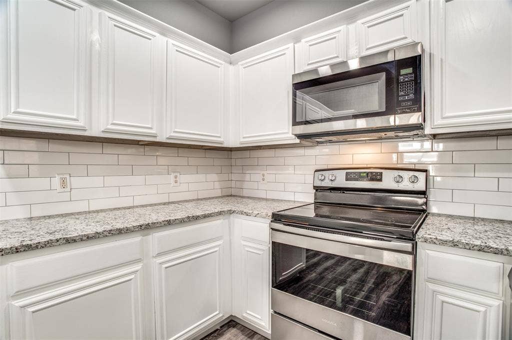 2364 Calendar Court, Grand Prairie, TX 75050 White cabinetry with crown molding, subway tile backsplash, stainless steel microwave, and stainless steel range