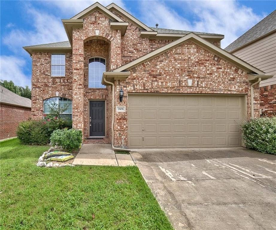 7108 Jessup Court, Plano, TX 75074 Brick exterior with arched entry, two-car garage, and established landscaping