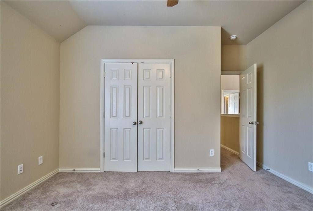 7108 Jessup Court, Plano, TX 75074 Vaulted ceiling, neutral wall paint, white trim, paneled interior doors, and carpet flooring