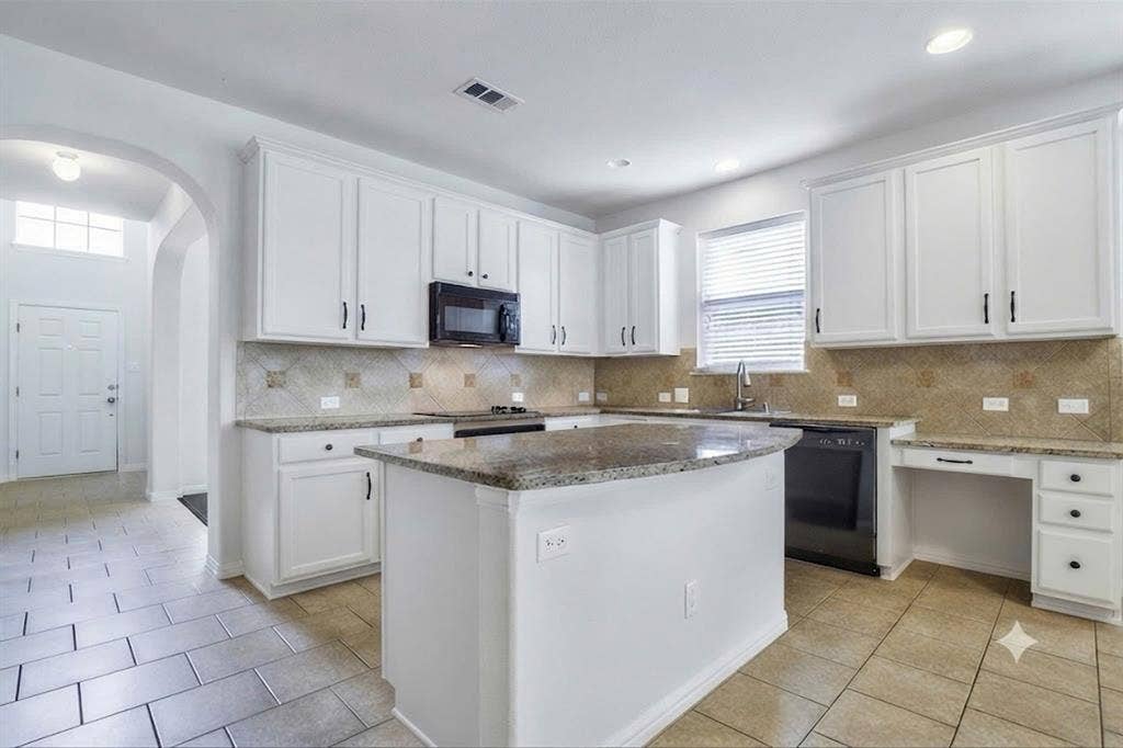 7108 Jessup Court, Plano, TX 75074 Kitchen featuring white cabinetry, granite countertops, tile backsplash, built-in microwave, and a center island