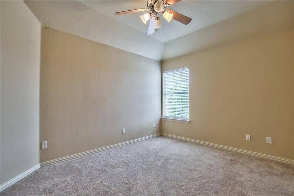 7108 Jessup Court, Plano, TX 75074 Vaulted ceiling with a ceiling fan light fixture, neutral carpeting, and a window with blinds