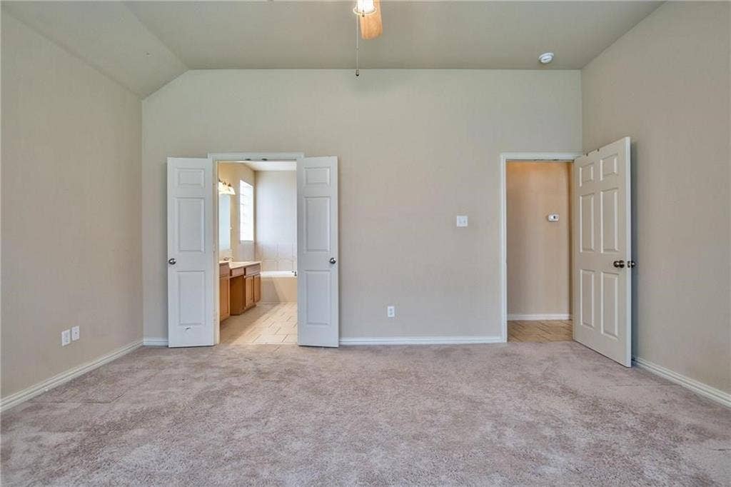 7108 Jessup Court, Plano, TX 75074 Vaulted ceiling with a ceiling fan, carpeted flooring, and neutral wall tones