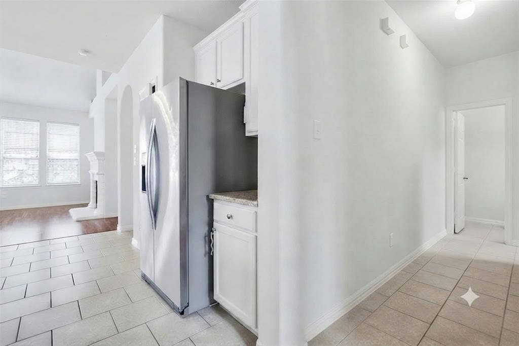 7108 Jessup Court, Plano, TX 75074 Kitchenette with white cabinetry, stainless steel refrigerator, and light-toned countertops