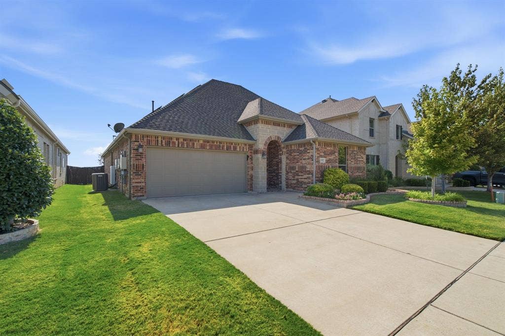 Brick and stone facade residence with an arched entry and attached two-car garage