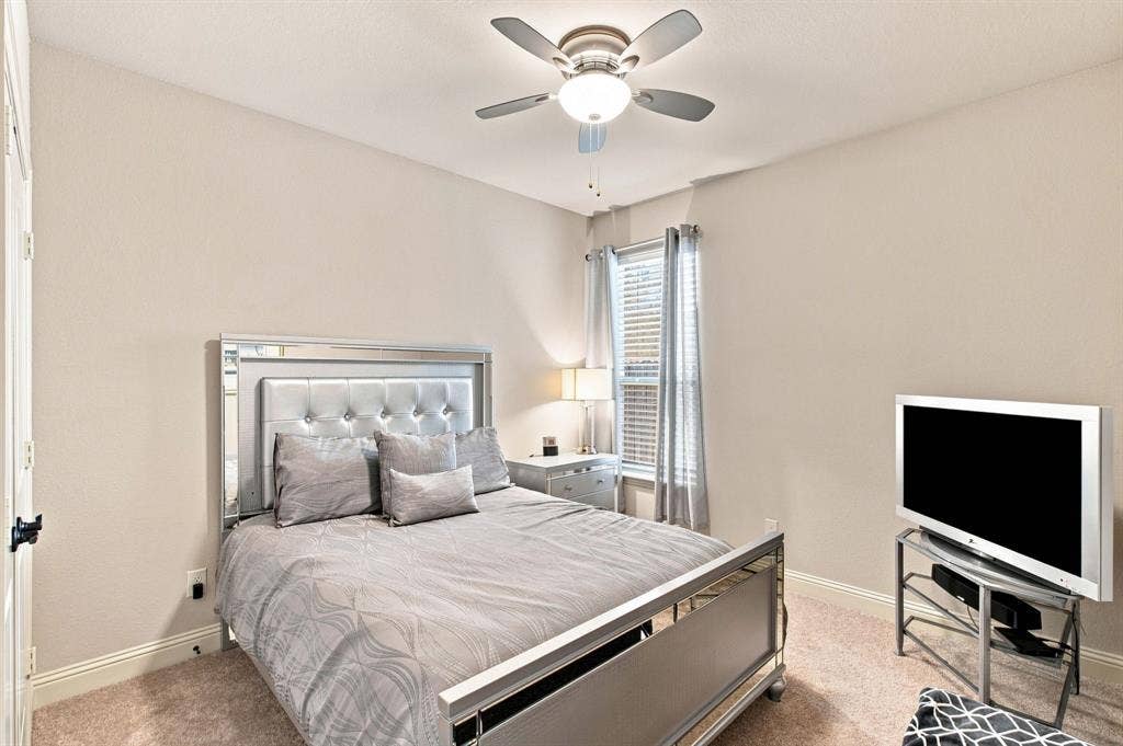 Recessed lighting and a ceiling fan are featured in this room with plush carpeting