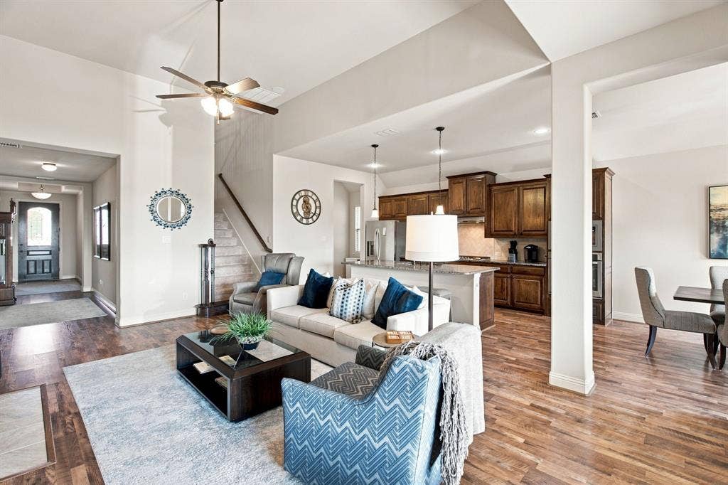 Vaulted ceilings with a ceiling fan, recessed lighting, wood-finish flooring, and a kitchen featuring wood cabinetry and pendant lighting