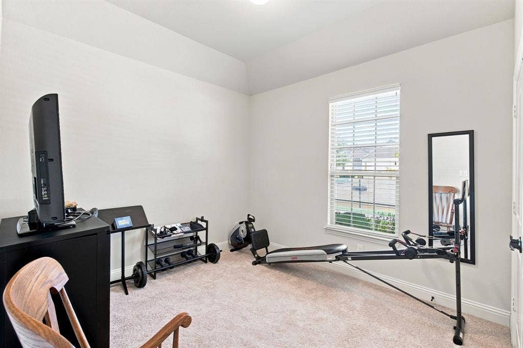 Tray ceiling with recessed lighting, single window with blinds, carpet flooring, and a white paneled door with black hardware