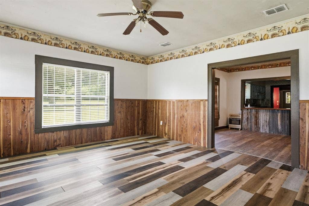 506 E Longview Street, Arp, TX 75750 Wood-finish flooring, wood paneling, and an overhead ceiling fan
