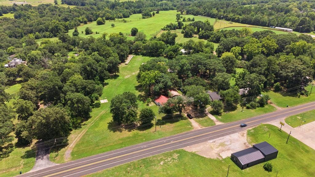 506 E Longview Street, Arp, TX 75750 Expansive property featuring mature trees, open green spaces, and direct road frontage