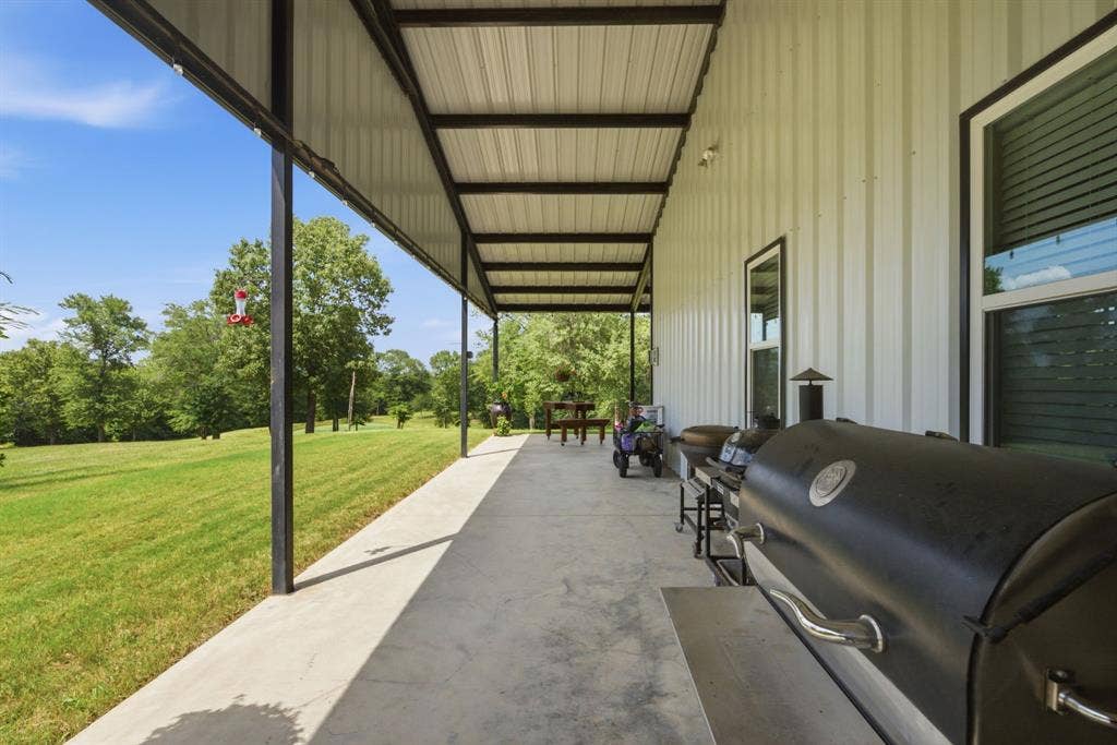 12842 Farm to Market 838, Overton, TX 75684 Expansive covered patio featuring a concrete surface and a metal roof structure