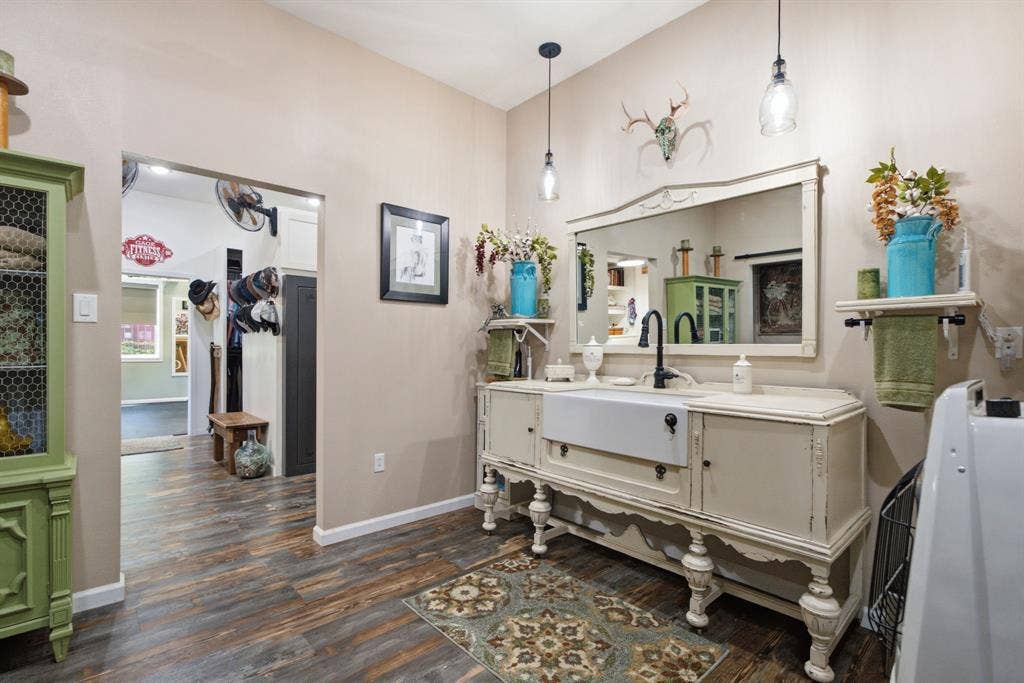 12842 Farm to Market 838, Overton, TX 75684 Wood-finish flooring, drop-in sink, vanity with storage, two pendant light fixtures, and a large wall mirror