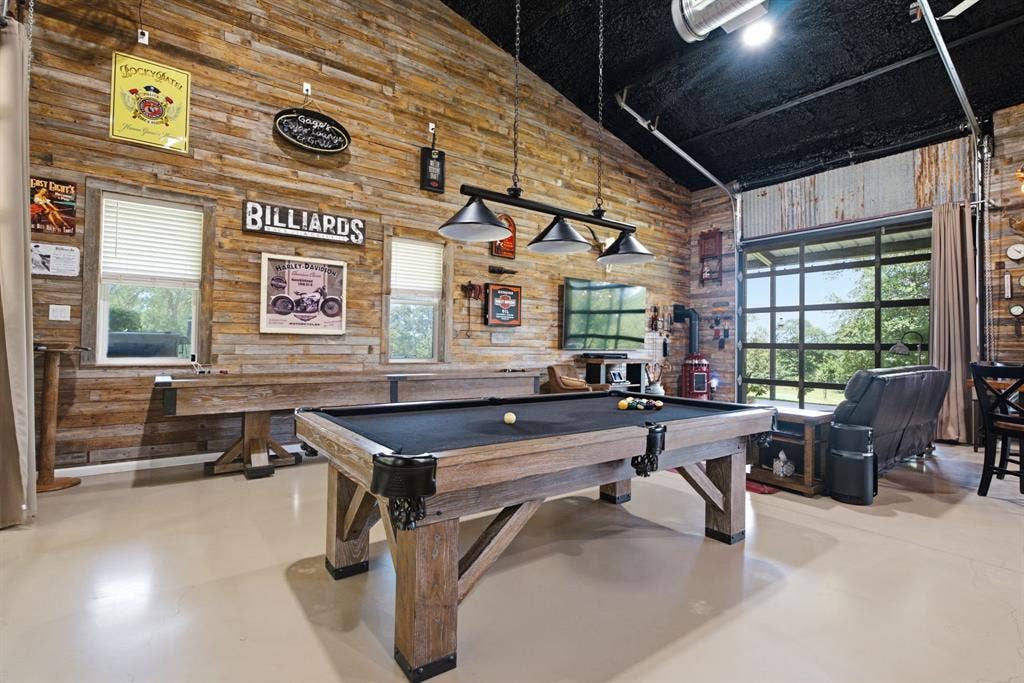 12842 Farm to Market 838, Overton, TX 75684 Vaulted ceiling with exposed beams, wood plank wall finishes, light-toned flooring, and a large glass garage door opening