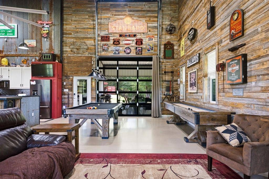 12842 Farm to Market 838, Overton, TX 75684 High ceilings, corrugated metal wall paneling, wood-finish wall paneling, overhead garage door with glass panes, and a built-in kitchen area