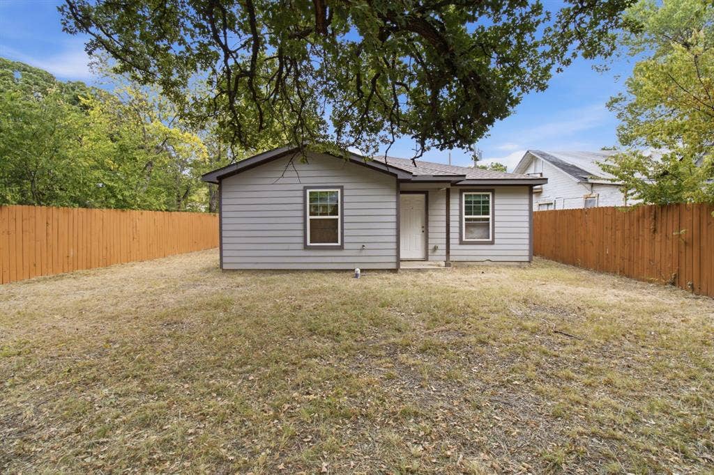 3923 Metropolitan Avenue, Dallas, TX 75210 Single-story residence featuring gray siding, a composite shingle roof, and white-framed windows