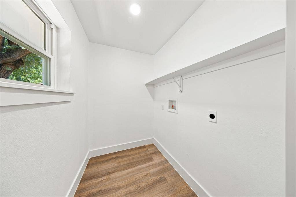 Utility space featuring wood-finish flooring, a window, overhead lighting, and an integrated shelf