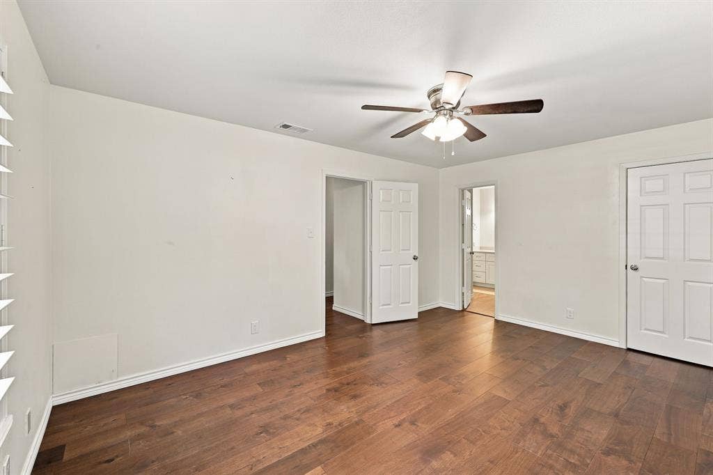 21121 County Road 1291, Flint, TX 75762 Wood-finish flooring, ceiling fan with light fixture, white interior doors, and window with white blinds