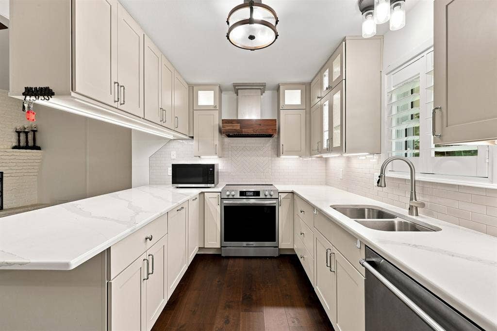 21121 County Road 1291, Flint, TX 75762 U-shaped kitchen with light cabinetry, white countertops, stainless steel appliances, and dark wood-finish flooring