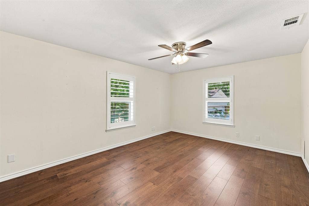21121 County Road 1291, Flint, TX 75762 Wood-finish flooring, two windows with plantation shutters, ceiling fan with integrated lighting, and neutral wall tones