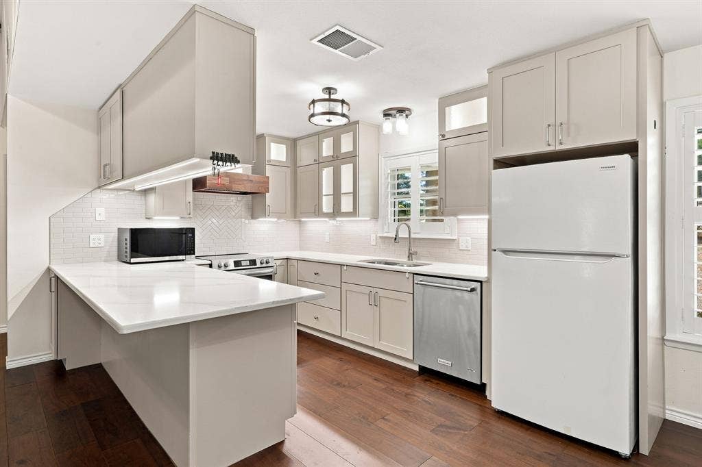 21121 County Road 1291, Flint, TX 75762 Kitchen featuring light-toned cabinetry, white countertops, stainless steel appliances, and dark wood-finish flooring