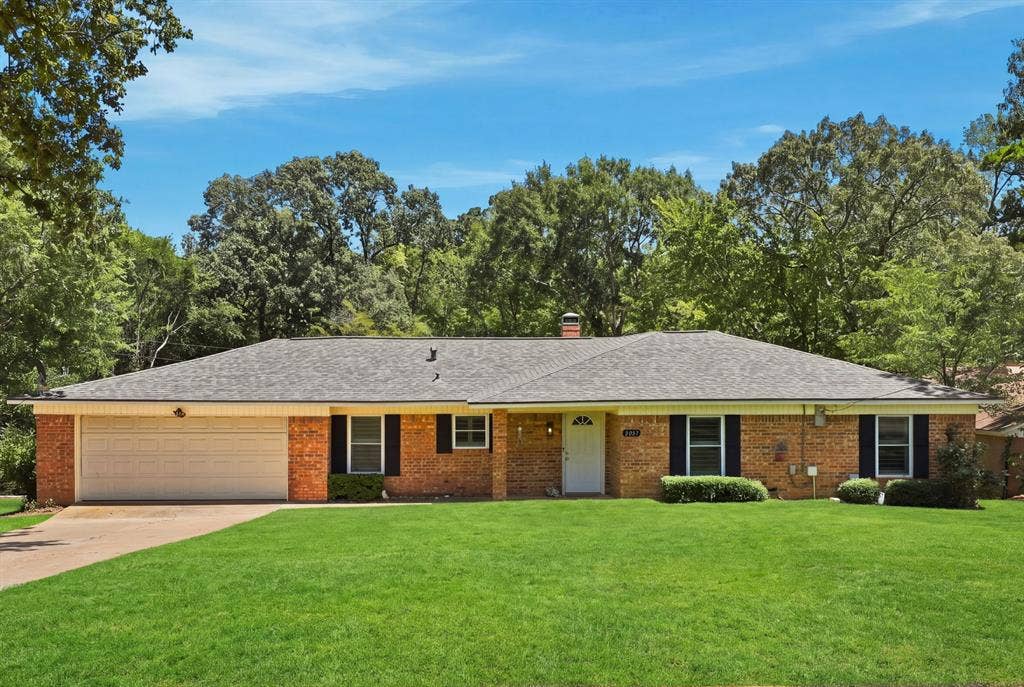 21121 County Road 1291, Flint, TX 75762 Brick exterior with a shingle roof, attached garage, and a lush green lawn