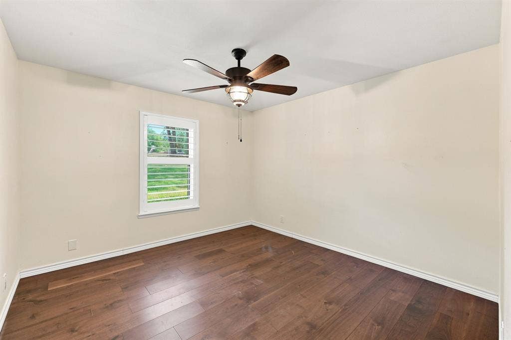 21121 County Road 1291, Flint, TX 75762 Wood-finish flooring, ceiling fan with integrated lighting, window with plantation shutters, and light-toned walls