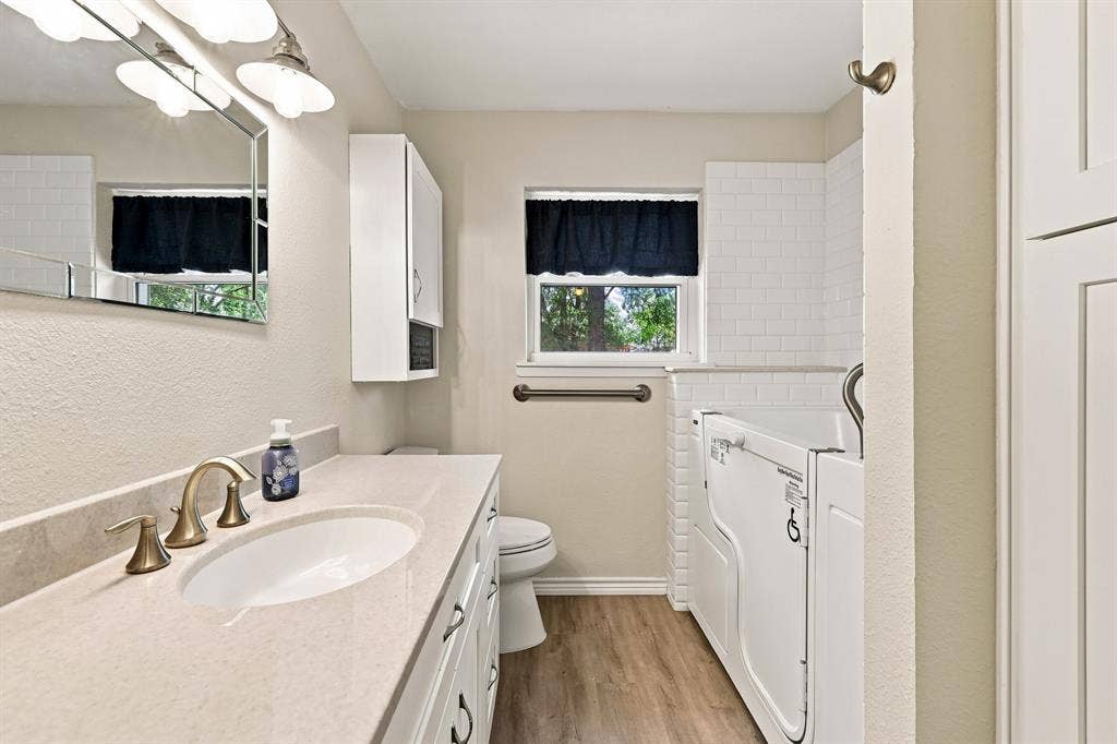 21121 County Road 1291, Flint, TX 75762 Bathroom featuring a vanity with an integrated sink, a walk-in tub, and wood-finish flooring