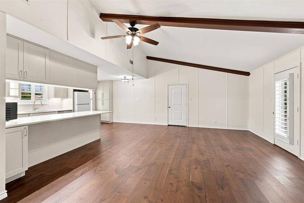 21121 County Road 1291, Flint, TX 75762 Vaulted ceilings with exposed wood beams, wood-finish flooring, white cabinetry, integrated kitchen lighting, and a kitchen island with a breakfast bar