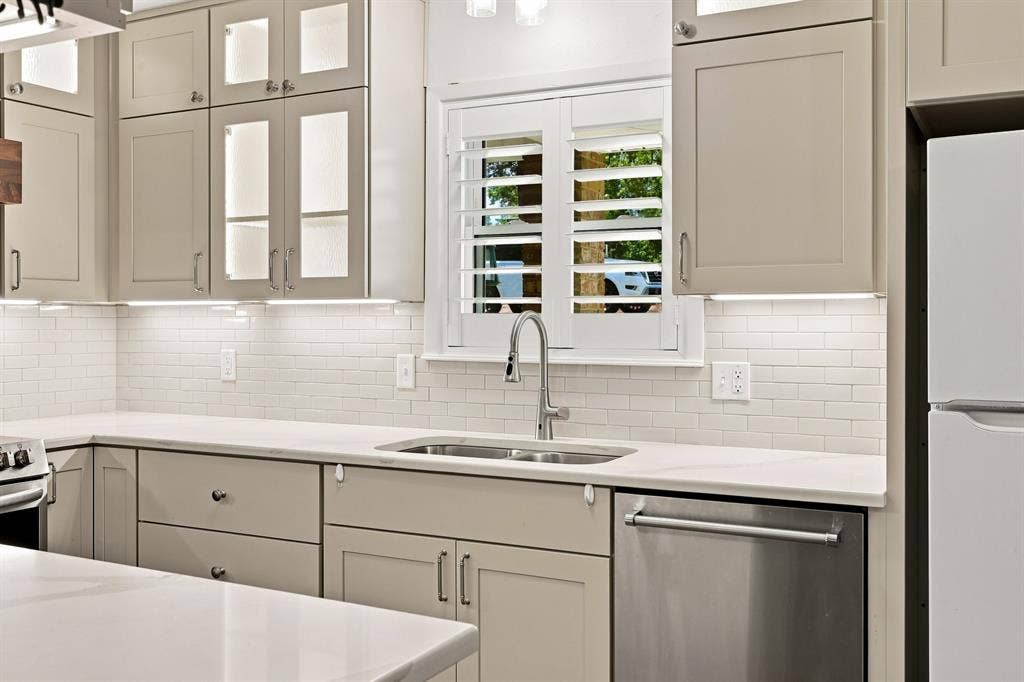 21121 County Road 1291, Flint, TX 75762 Kitchen featuring light-toned cabinetry, stainless steel sink, subway tile backsplash, and under-cabinet lighting