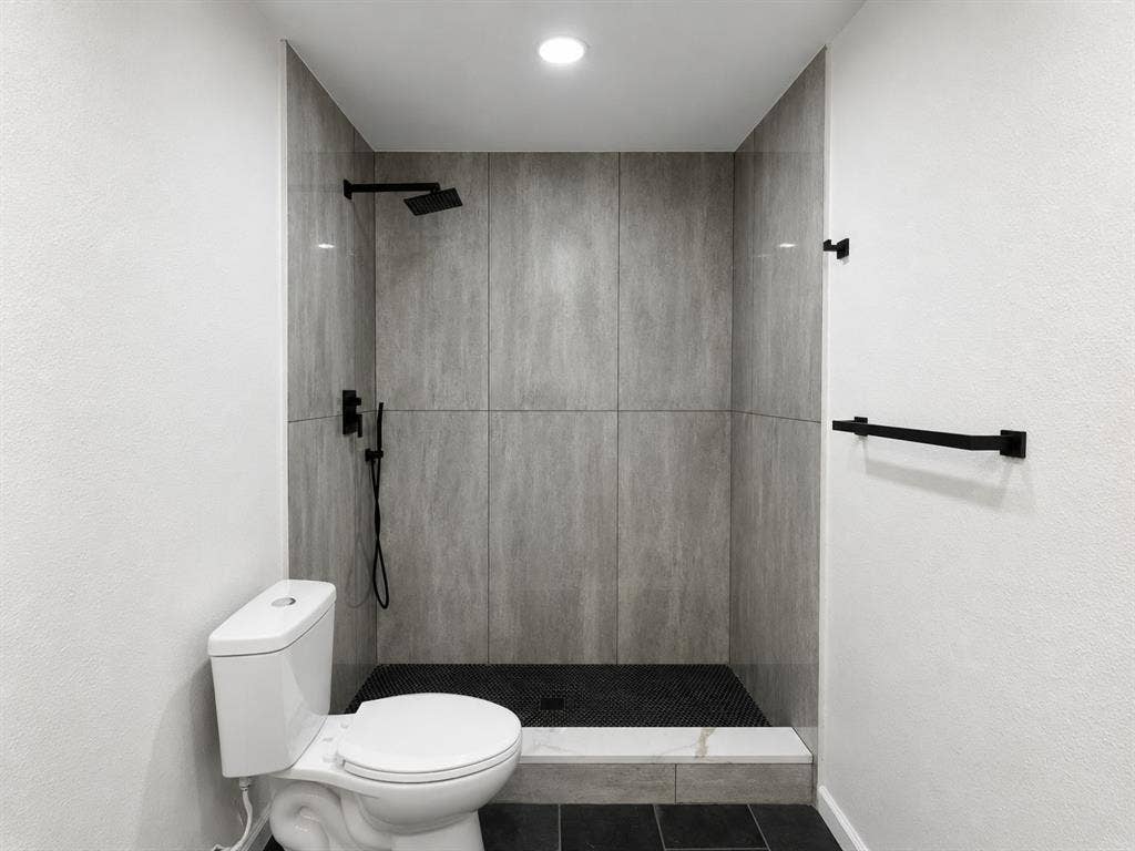 1842 Delmar Drive, Garland, TX 75040 Walk-in shower with large-format wall tiling and dark-toned mosaic floor