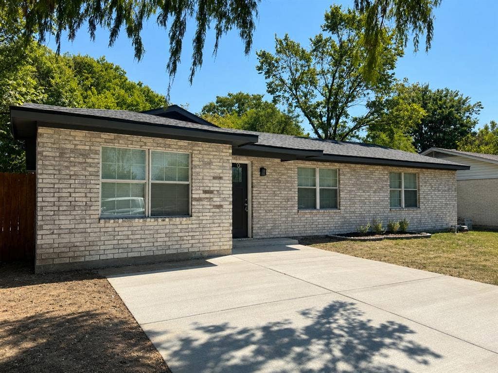1842 Delmar Drive, Garland, TX 75040 Light brick facade with dark trim, asphalt shingle roof, and a concrete driveway