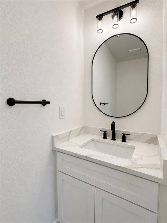 1842 Delmar Drive, Garland, TX 75040 White shaker-style vanity with an integrated rectangular sink and a marble-finish countertop